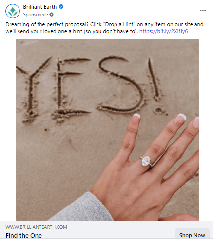 Facebook上的一个广告，一个女人手上戴着订婚戒指，沙子上刻着“是的”