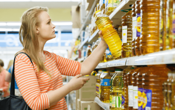 一个女人从杂货店的货架上拿橄榄油